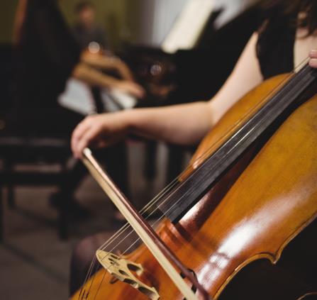 Mid-section of female student playing double bass