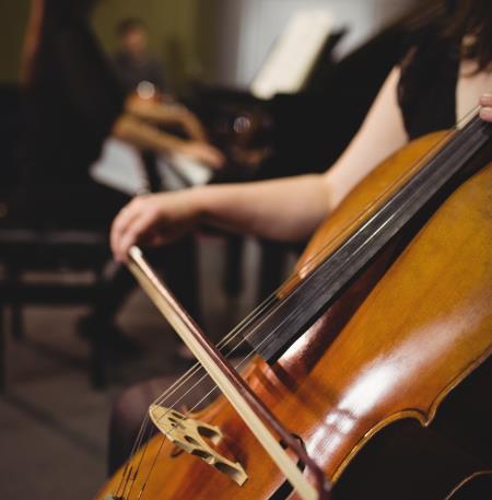 Mid-section of female student playing double bass